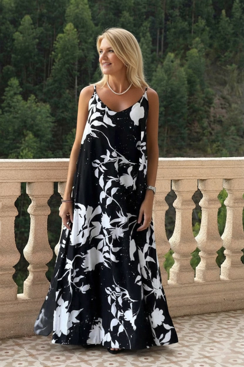 Margaret & Pearl black and white floral print sleeveless maxi dress with pockets and a slit. Polyester blend.